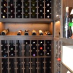 This custom home wine cellar under the stairs features multiple racking and display options for your favorite wines.